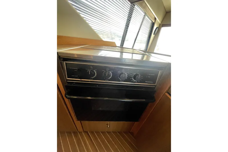 Slide: The Image of 2001 Bayliner 3988 Command Bridge Motoryacht kitchen oven with control knobs. - 13