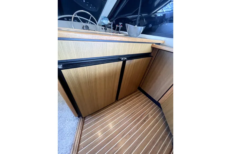 Slide: The Image of 2001 Bayliner 3988 Command Bridge Motoryacht interior with wood cabinetry and steering wheel. - 14