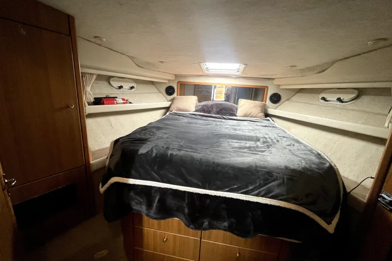 Slide: The Image of Cozy bedroom in 2001 Bayliner 3988 Command Bridge Motoryacht with plush bedding and wood cabinetry. - 27