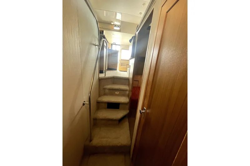 Slide: The Image of Interior staircase of 2001 Bayliner 3988 Command Bridge Motoryacht, featuring carpeted steps and wooden paneling. - 33