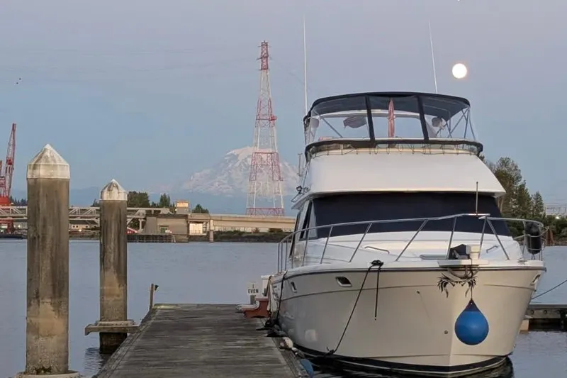 Slide: The Image of 2001 Bayliner 3988 Command Bridge Motoryacht docked with scenic mountain and moon backdrop. - 49