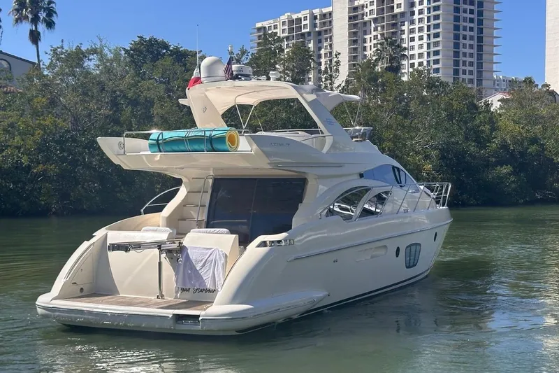 Slide: The Image of Luxury 2007 Azimut 55E yacht docked in scenic waters, surrounded by lush greenery. - 11