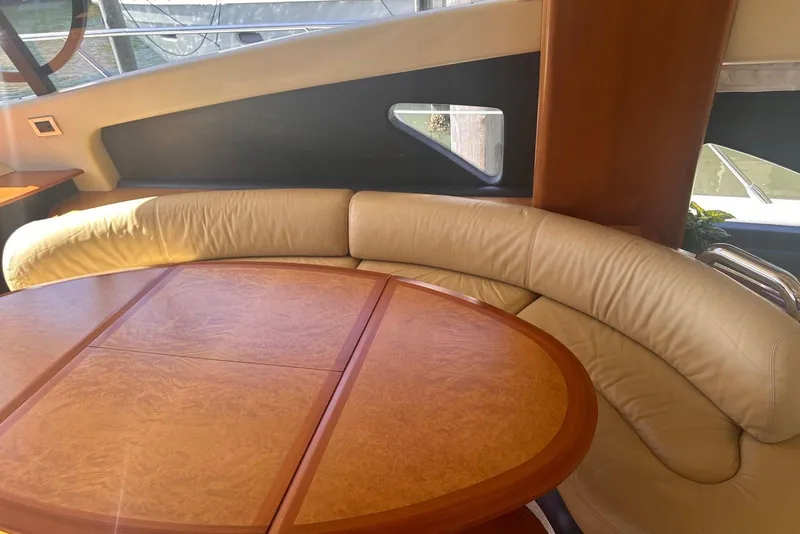 Slide: The Image of Luxurious interior of 2007 Azimut 55E yacht with curved leather seating and wooden table. - 14