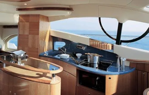 Slide: The Image of 2007 Azimut 55E yacht cruising on a calm river with lush greenery and buildings in the background. - 2