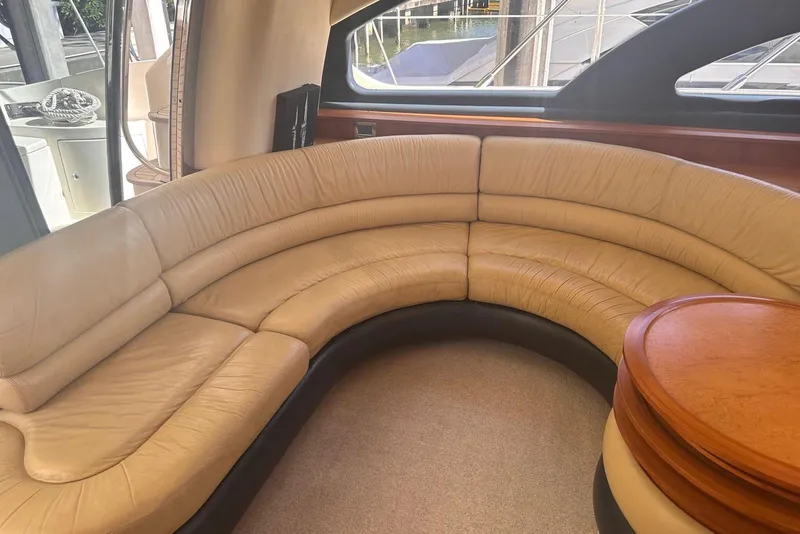 Slide: The Image of Luxurious interior of 2007 Azimut 55E yacht with curved leather seating and wooden table. - 22