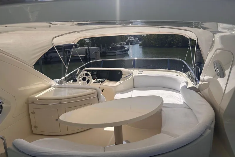 Slide: The Image of Luxurious 2007 Azimut 55E yacht interior with elegant seating and helm, docked in a serene marina. - 29