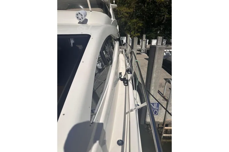 Slide: The Image of 2007 Azimut 55E yacht docked, showcasing sleek white exterior and railing. - 37