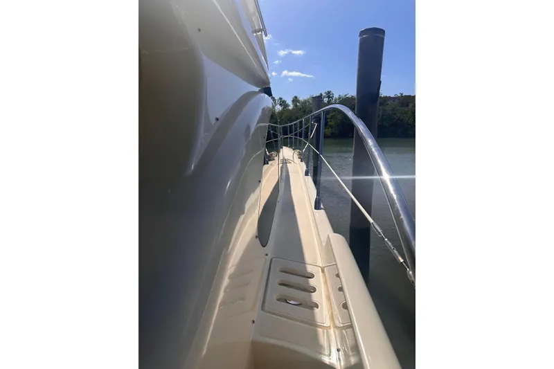 Slide: The Image of 2007 Azimut 55E yacht side view with railing, docked under clear blue sky. - 48