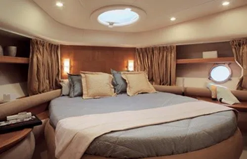 Slide: The Image of 2007 Azimut 55E yacht cruising on a serene waterway with lush greenery and buildings. - 5