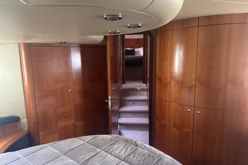 Slide: The Image of Luxurious interior of 2007 Azimut 55E yacht with wooden cabinetry and plush bedding. - 53