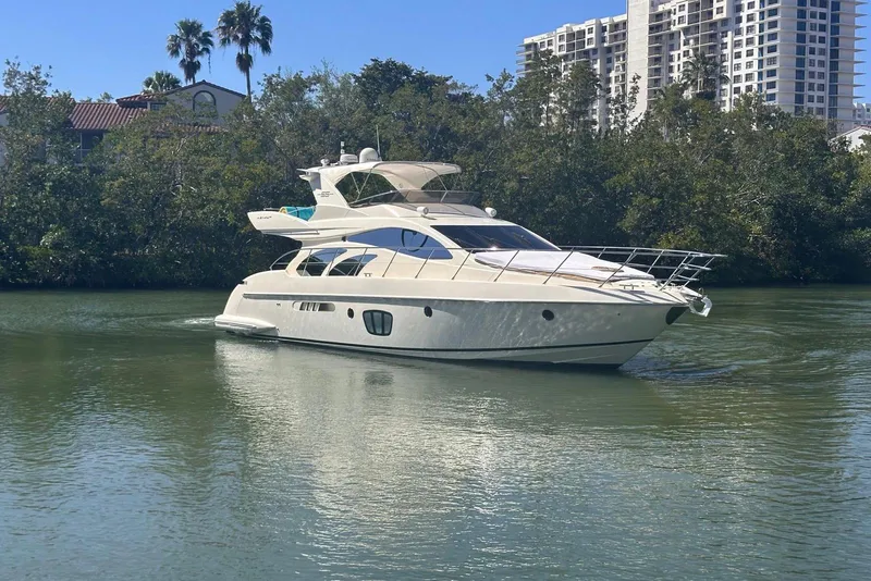 Slide: The Image of 2007 Azimut 55E yacht cruising on a calm river with lush greenery. - 8