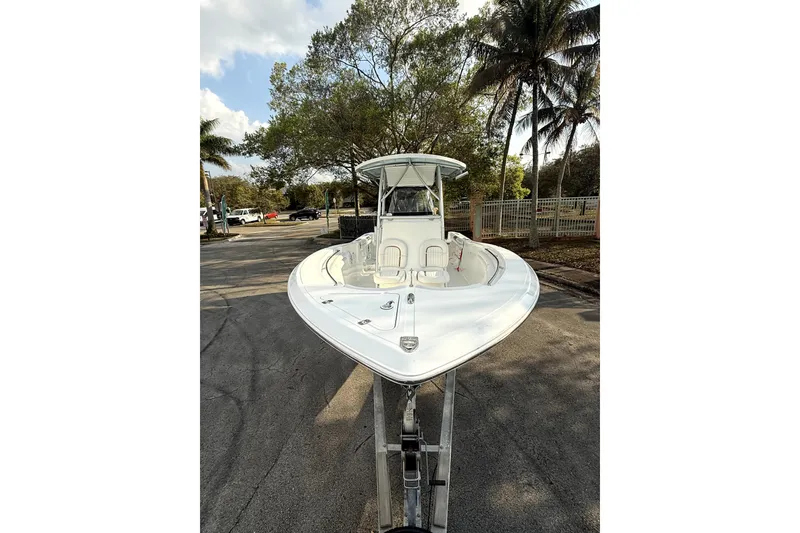 Slide: The Image of 2008 Sea Fox 256 Center Console boat on trailer, surrounded by trees and palm trees. - 10