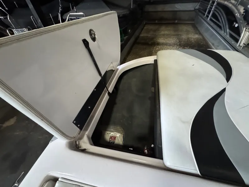 Slide: The Image of 2006 Correct Craft Air Nautique 210 boat with open storage compartment. - 26