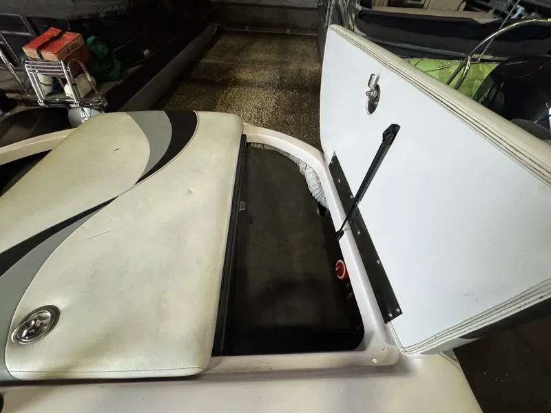 Slide: The Image of 2006 Correct Craft Air Nautique 210 with open storage compartment. - 27