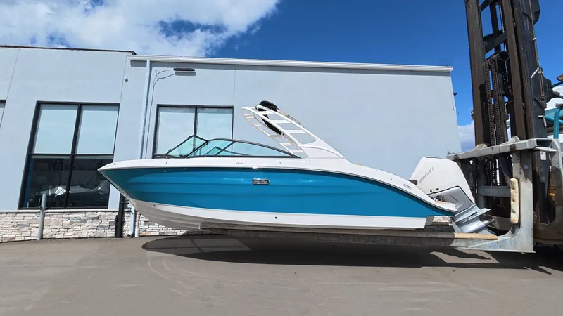 Slide: The Image of 2026 Sea Ray SDX 250 Outboard boat in front of a building. - 0