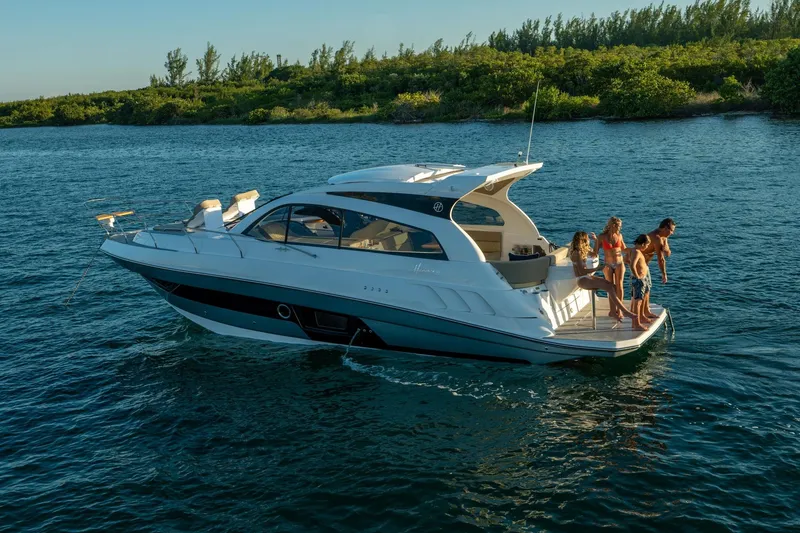 Slide: The Image of 2026 Hanover 375 yacht with people enjoying the water, surrounded by lush greenery. - 104