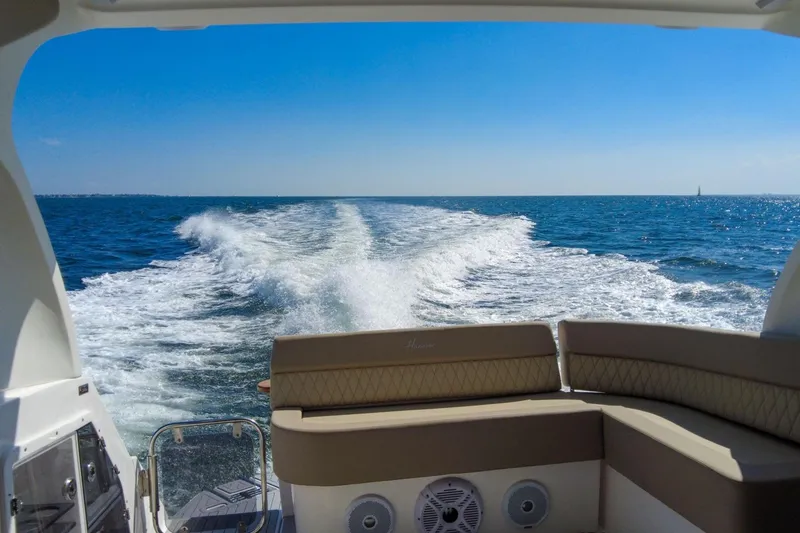 Slide: The Image of Luxury Hanover 375 boat cruising on open sea, leaving a wake trail, under clear blue sky. - 124