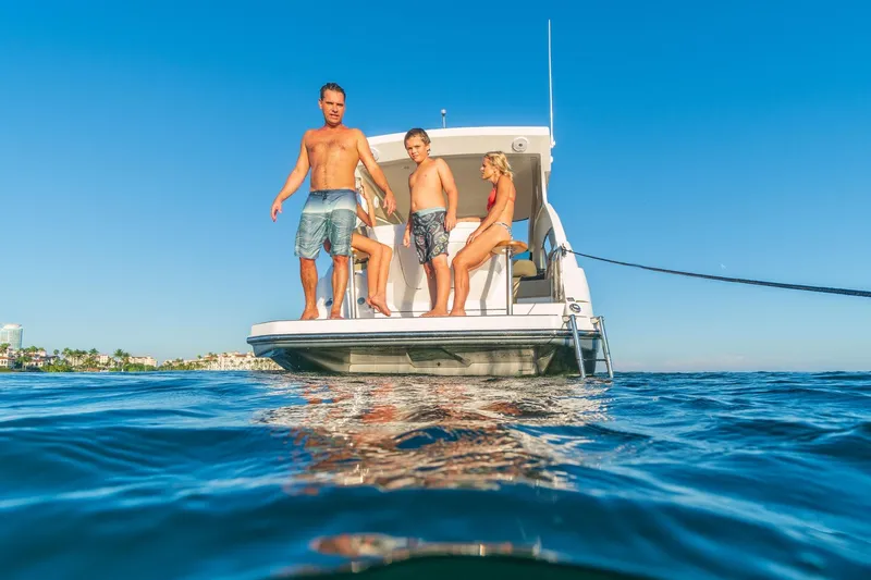 Slide: The Image of Family enjoying sunny day on Hanover 375 boat, 2026 model, in clear blue waters. - 37