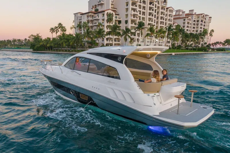 Slide: The Image of Luxurious 2026 Hanover 375 yacht cruising near waterfront residences at sunset. - 4