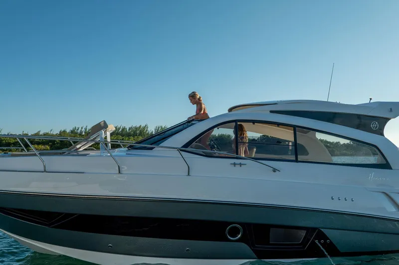 Slide: The Image of 2026 Hanover 375 yacht cruising on a sunny day with passengers on deck. - 93