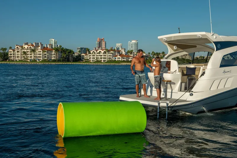 Slide: The Image of Family enjoying leisure time on a 2026 Hanover 375 yacht near waterfront buildings. - 96