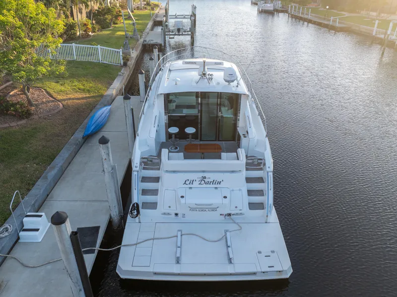 Slide: The Image of 2018 Cruisers Yachts 50 Cantius docked in a serene canal setting. - 3