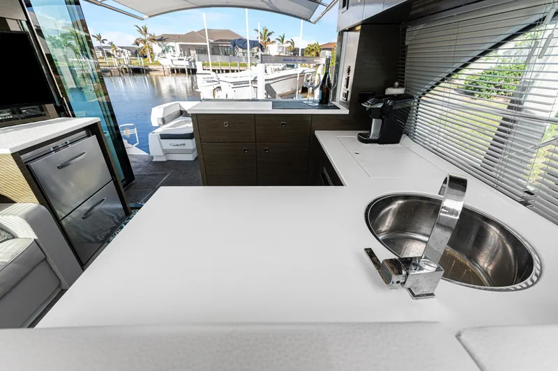 Slide: The Image of 2018 Cruisers Yachts 50 Cantius kitchen with modern sink, countertop, and marina view. - 41