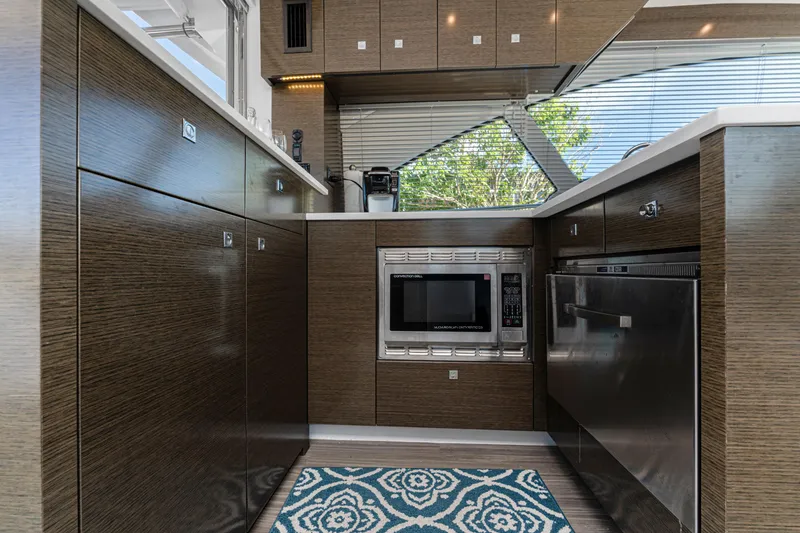 Slide: The Image of Modern kitchen interior of 2018 Cruisers Yachts 50 Cantius with wood cabinetry and appliances. - 45