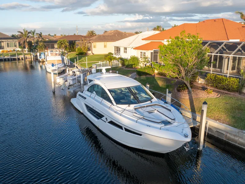 Slide: The Image of 2018 Cruisers Yachts 50 Cantius docked in a scenic residential canal. - 4