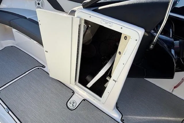 Slide: The Image of 2021 Yamaha AR210 boat storage compartment with open hatch, showcasing interior details. - 15