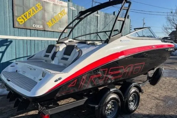 Slide: The Image of 2021 Yamaha Boats AR210 on trailer, featuring sleek design and vibrant red accents. - 2
