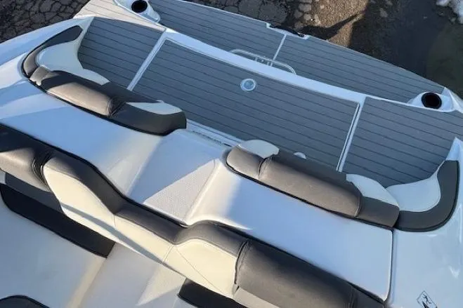 Slide: The Image of 2021 Yamaha Boats AR210 rear seating and deck, featuring sleek design and comfortable cushions. - 29