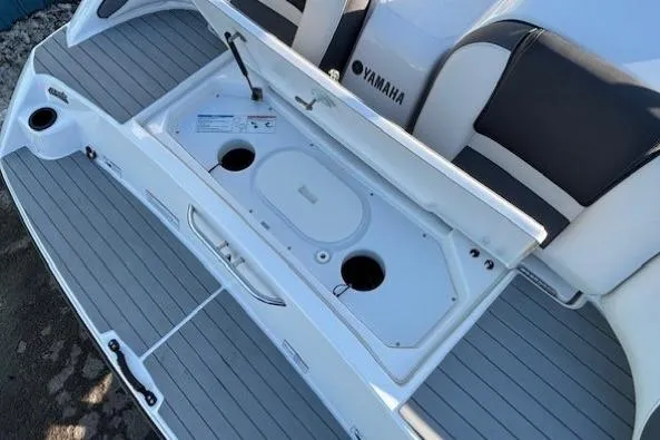 Slide: The Image of 2021 Yamaha AR210 boat interior with open storage compartment and seating. - 30