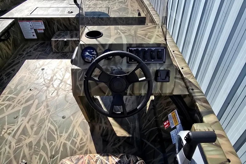 Slide: The Image of 2026 Lowe Roughneck RX2070 SC boat interior with camouflage design and steering console. - 8