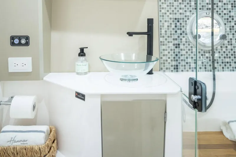 Slide: The Image of Modern bathroom in 2026 Hanover 387 RV with glass sink and mosaic tiles. - 34