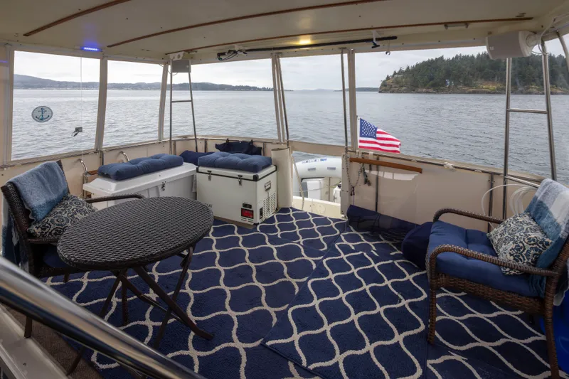 Slide: The Image of 1990 Tollycraft 44 Cockpit Motor Yacht interior with seating, table, and ocean view. - 10
