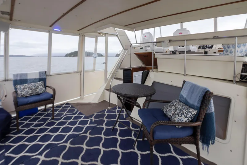 Slide: The Image of 1990 Tollycraft 44 Cockpit Motor Yacht interior with seating, table, and ocean view. - 11