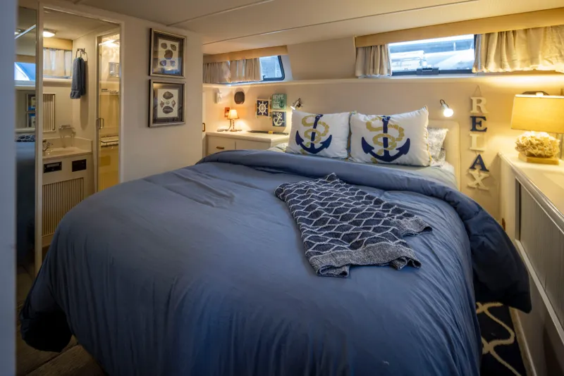Slide: The Image of Cozy bedroom in 1990 Tollycraft 44 Cockpit Motor Yacht with nautical decor and soft lighting. - 23