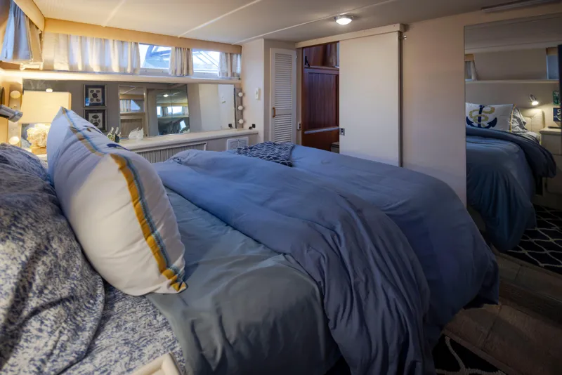 Slide: The Image of Cozy bedroom interior of 1990 Tollycraft 44 Cockpit Motor Yacht with blue bedding. - 25