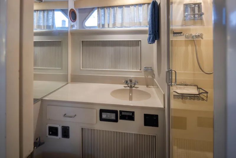 Slide: The Image of 1990 Tollycraft 44 Cockpit Motor Yacht bathroom with sink, shower, and storage. - 26