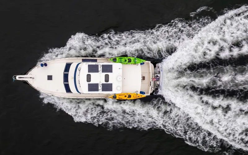 Slide: The Image of Overhead view of 1990 Tollycraft 44 Cockpit Motor Yacht cruising with kayaks. - 4