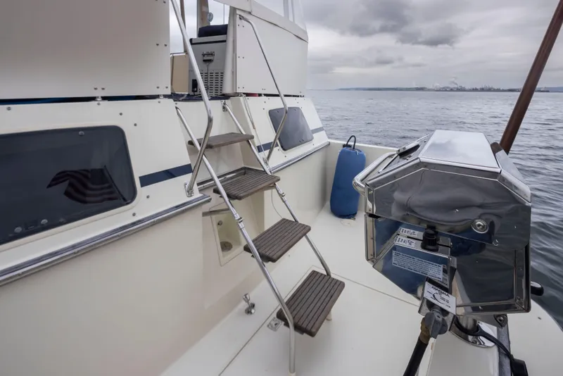 Slide: The Image of 1990 Tollycraft 44 Cockpit Motor Yacht deck with stairs and grill, overlooking calm waters. - 40