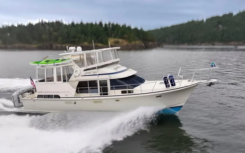 Slide: The Image of 1990 Tollycraft 44 Cockpit Motor Yacht cruising on a scenic waterway. - 6