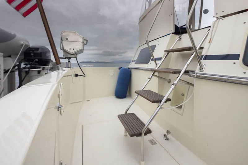 Slide: The Image of 1990 Tollycraft 44 Cockpit Motor Yacht deck with stairs and American flag. - 9