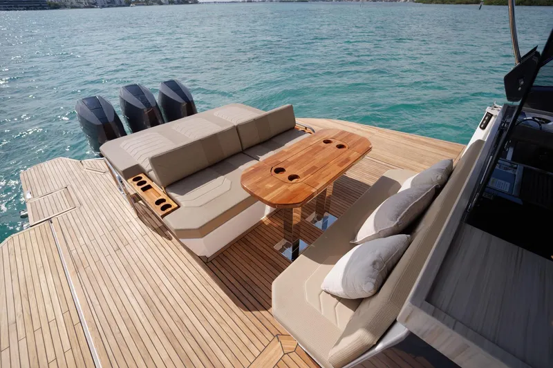 Slide: The Image of Luxurious Hanover 447 yacht deck with seating, table, and triple engines on clear water. - 32