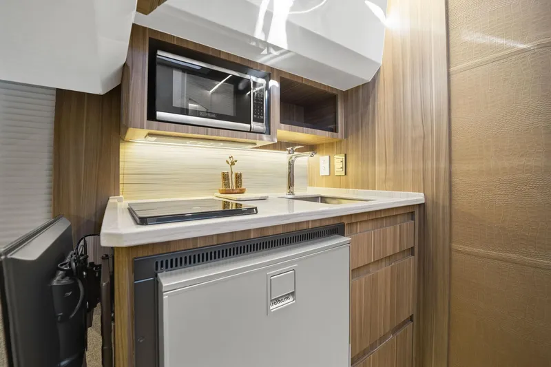 Slide: The Image of Compact kitchen in 2026 Hanover 447 RV with microwave, sink, and fridge. - 46
