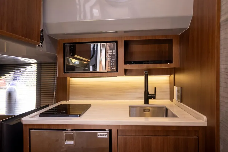 Slide: The Image of Modern kitchen in 2026 Hanover 447 RV with microwave, sink, and induction cooktop. - 10