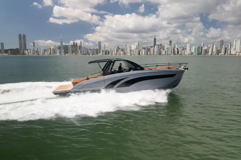 Slide: The Image of 2026 Hanover 447 yacht cruising on water with city skyline in background. - 2