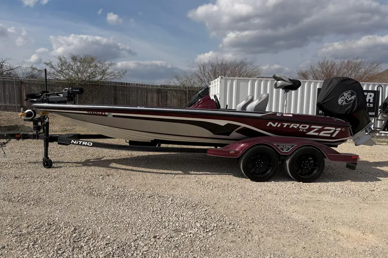 The Image of 2024 Nitro Z21 XL Pro bass boat on trailer, parked outdoors under cloudy sky. - 0