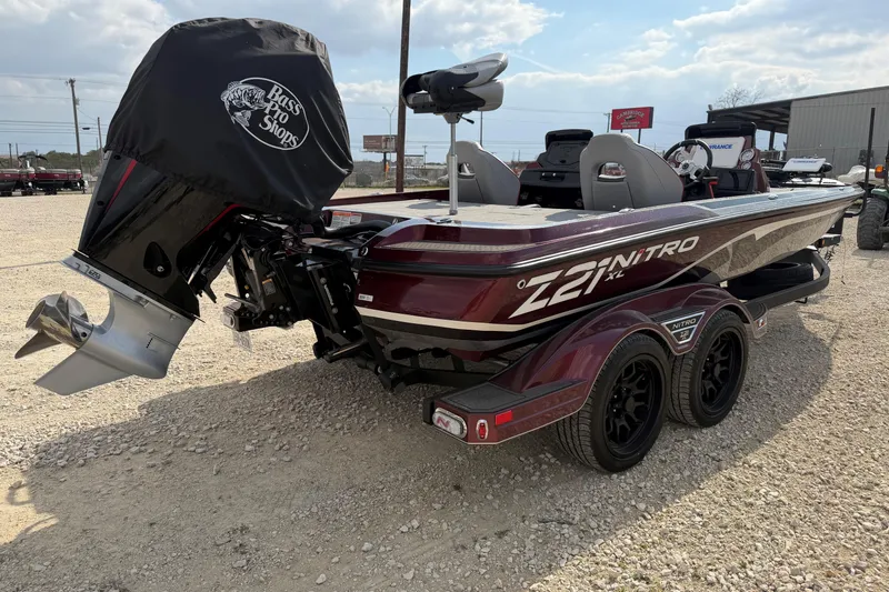Slide: The Image of 2024 Nitro Z21 XL Pro boat with dual axle trailer, parked outdoors. - 2
